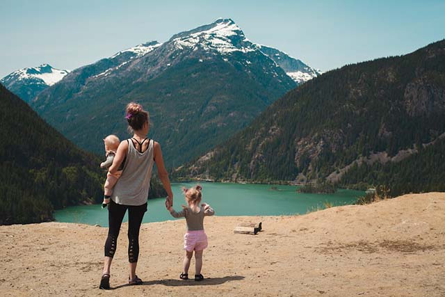 A mother and her two children enjoying the outdoor view.